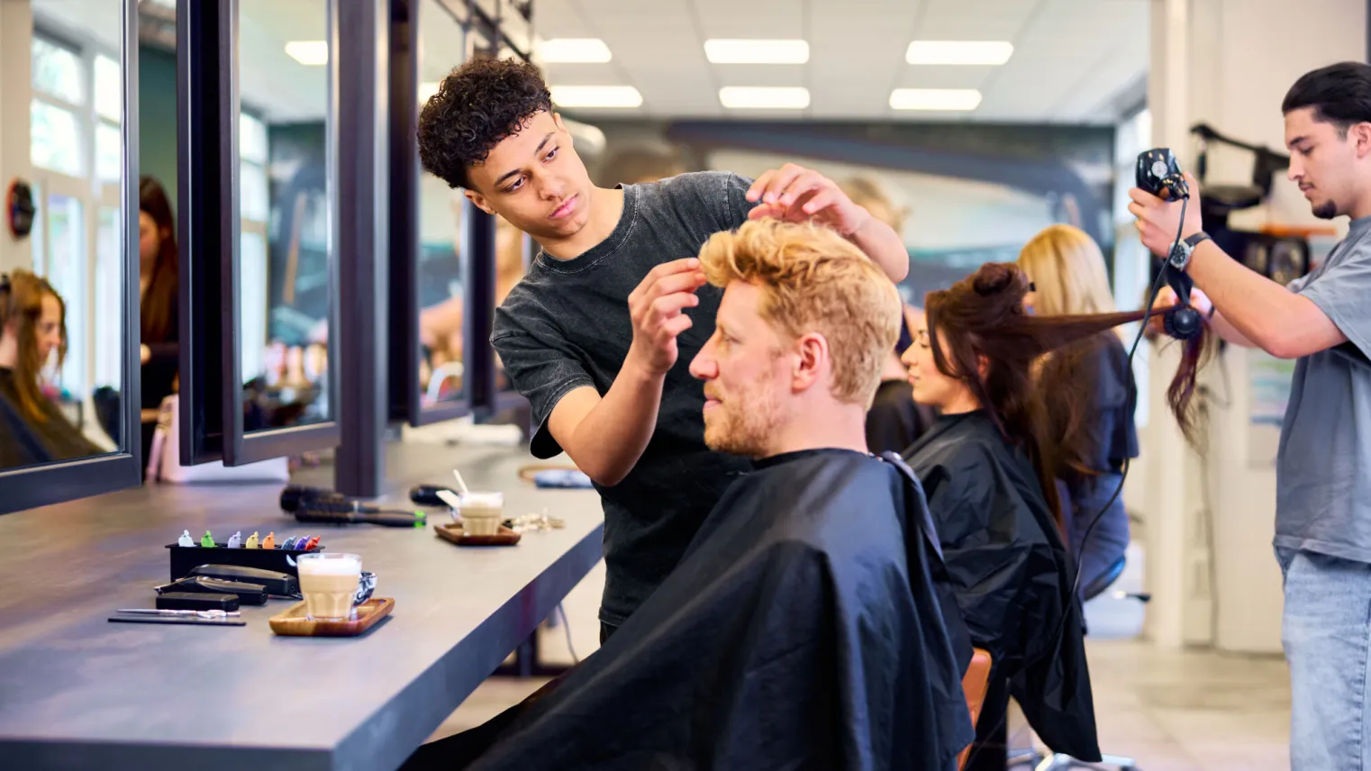 Student Kapper maakt het kapsel van een klant mooi