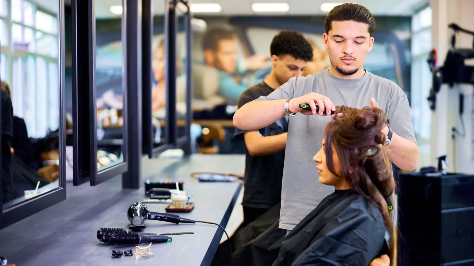 Student Kapper krult het haar van een klant