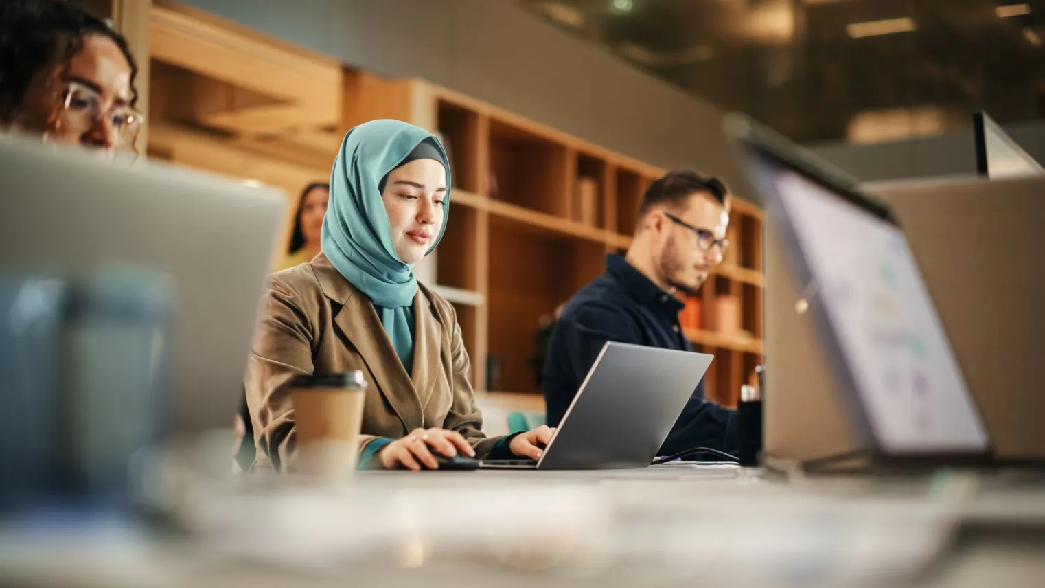 Studenten Marketing & Communicatie werken samen achter laptop tijdens stage