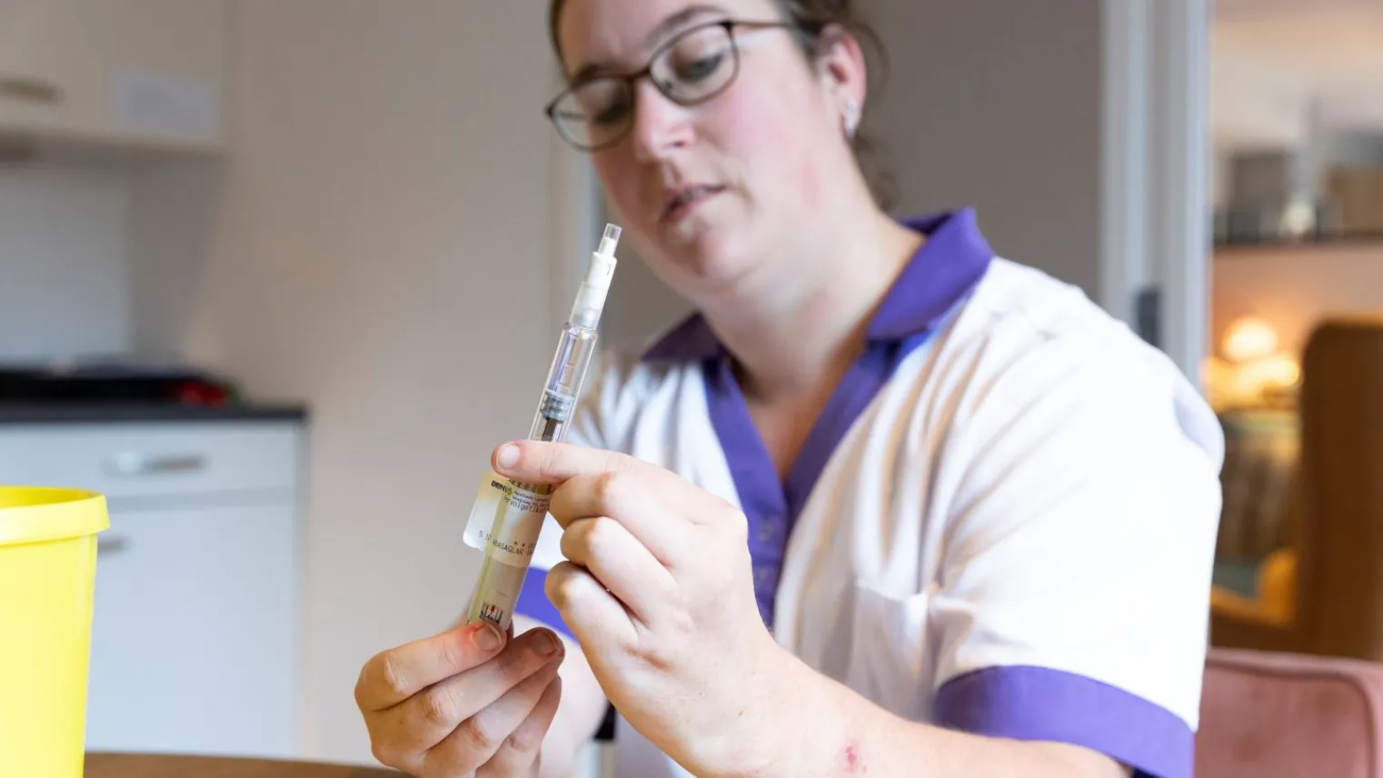 Een deelnemer van het keuzedeel verzorgende en verpleegtechnische handeling houdt injectiespuit vast.