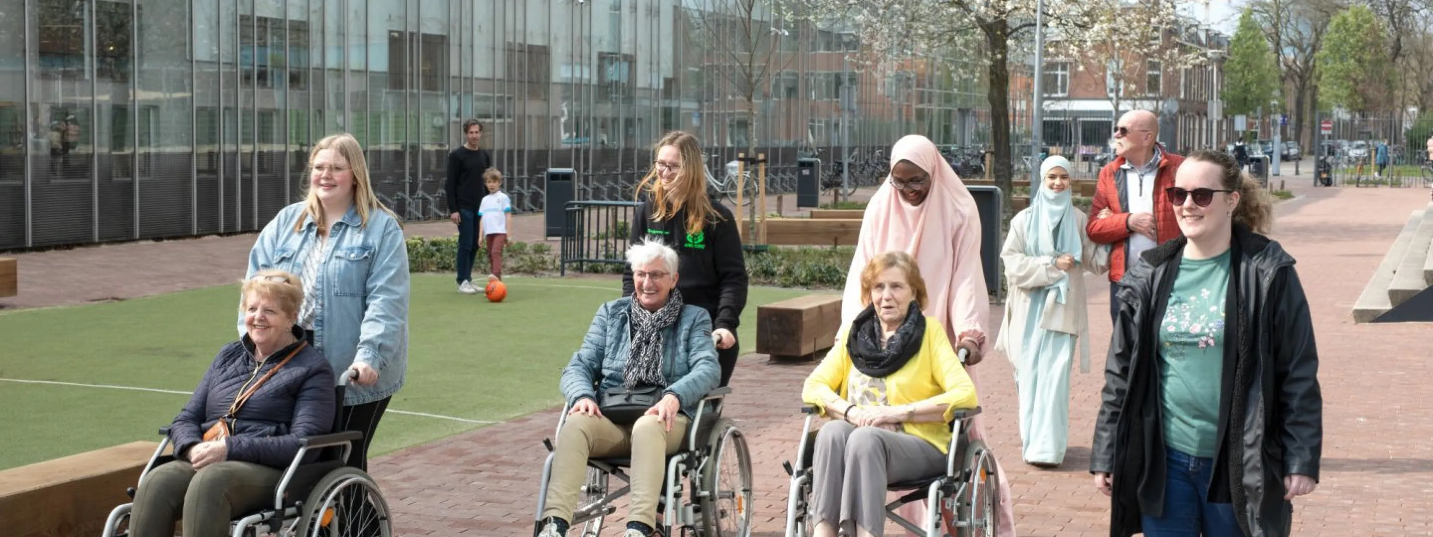 Studenten Persoonlijk Begeleider Maatschappelijke Zorg & Sociaal Werk lopen met cliënten buiten