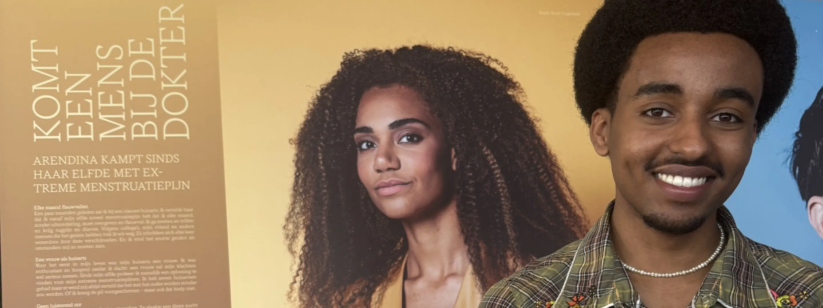 Yonathan poseert voor een bord met tekst