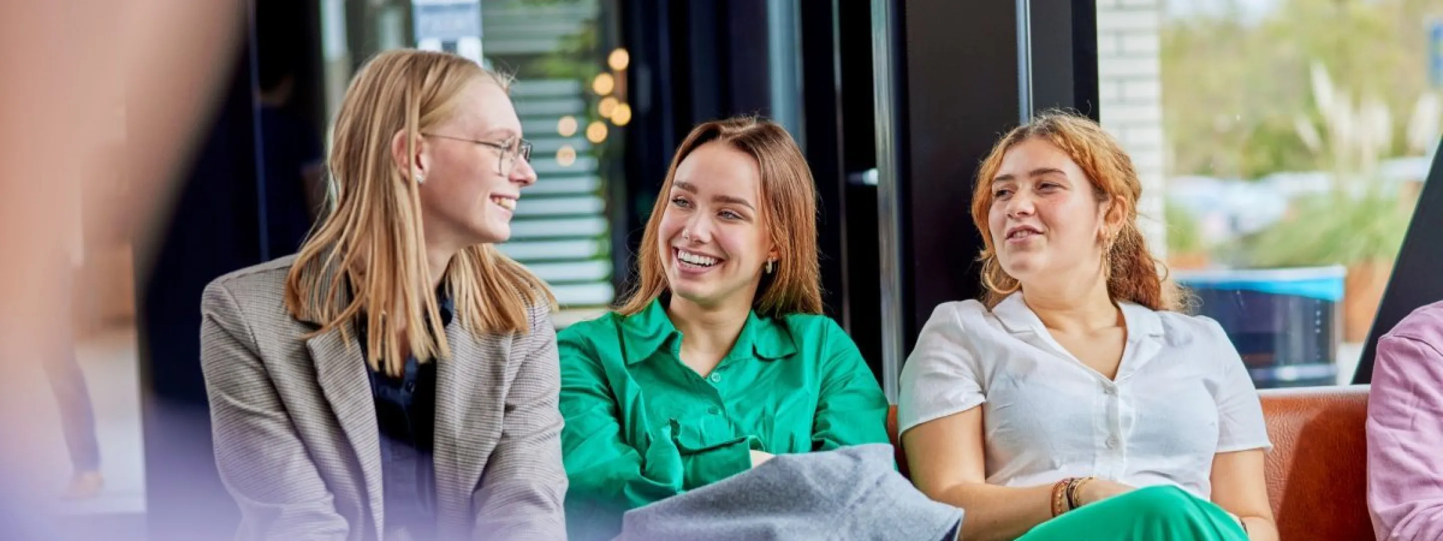 Drie studenten zitten op een rijtje op de bank
