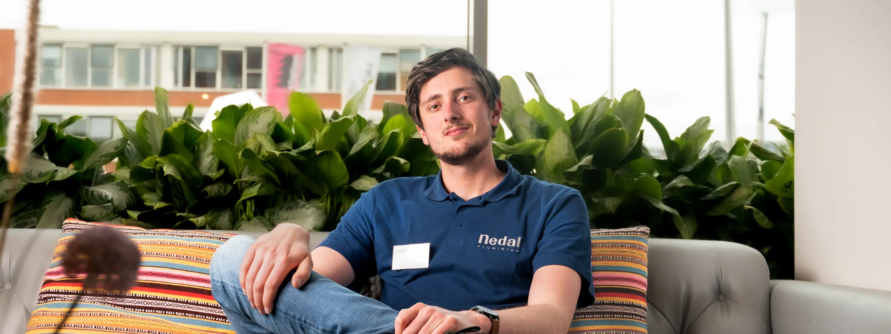 Siebe Hornman, project engineer Nedal, zit op een bank en kijkt in camera. 