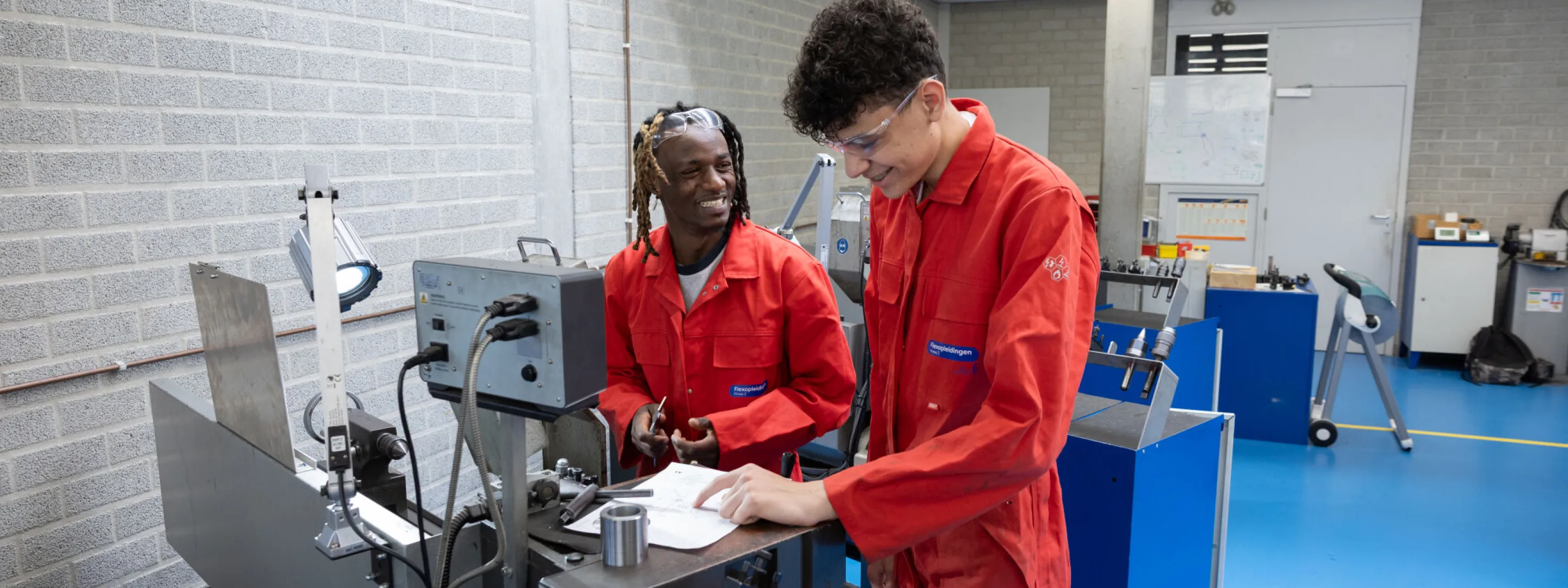 Studenten Flexopleiding Medewerker Techniek lachen bij metaalbewerkingsmachine