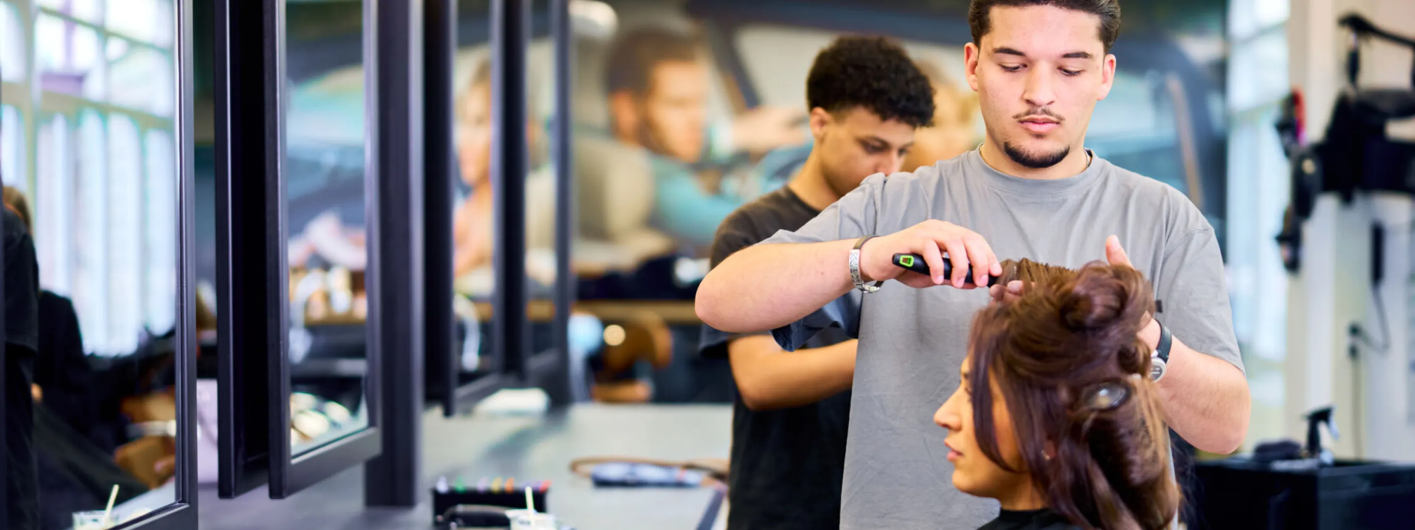 Student Haarstylist maakt het haar van een klant mooi