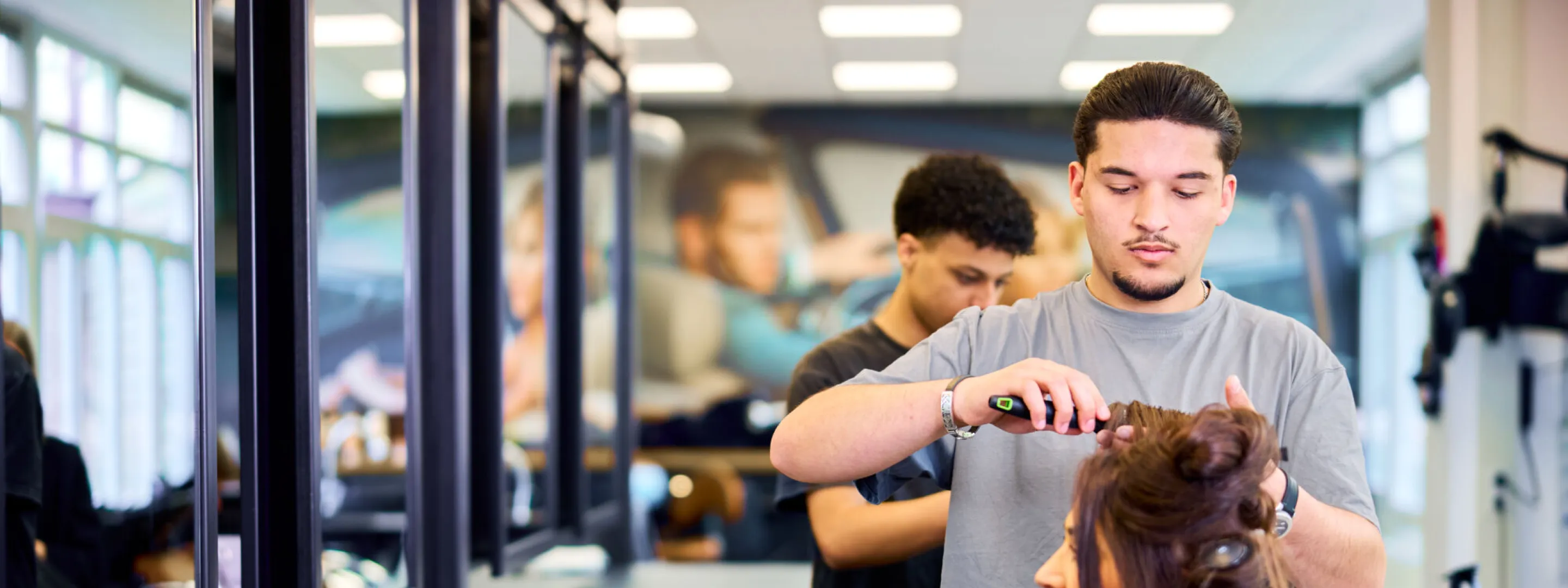Student Haarstylist maakt het haar van een klant mooi