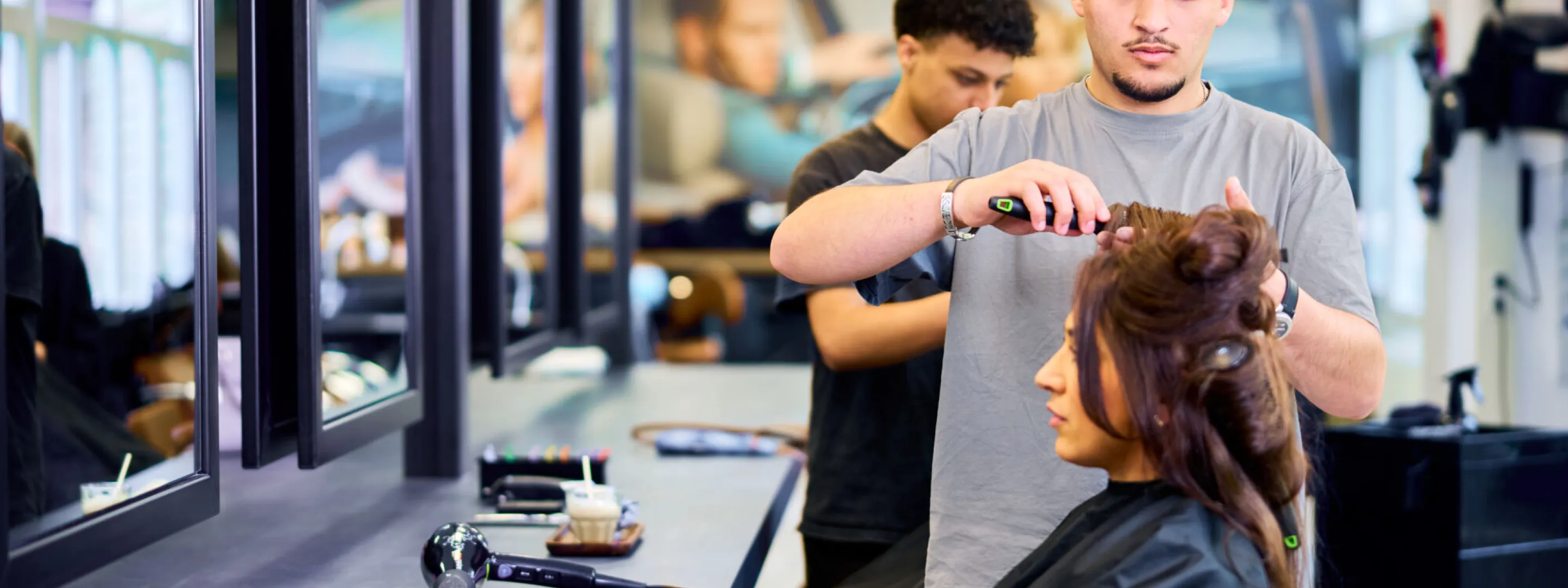 Student Haarstylist maakt het haar van een klant mooi