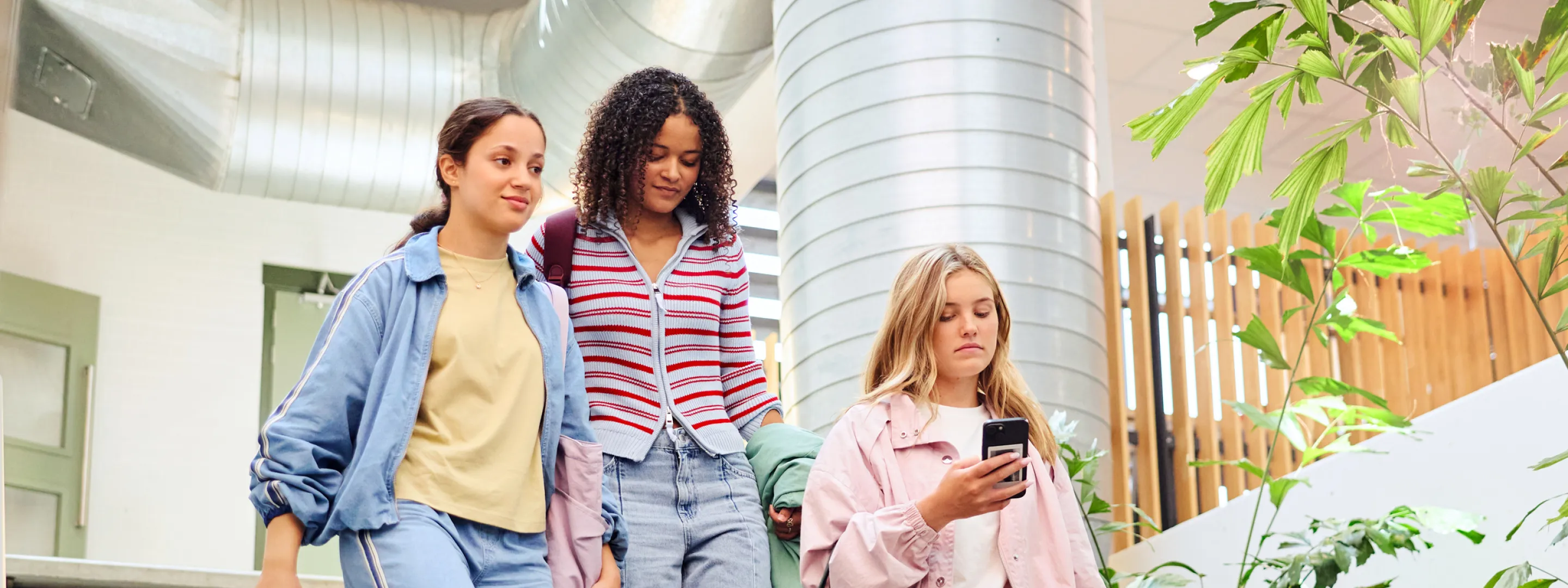 Drie studenten lopen samen een trap af