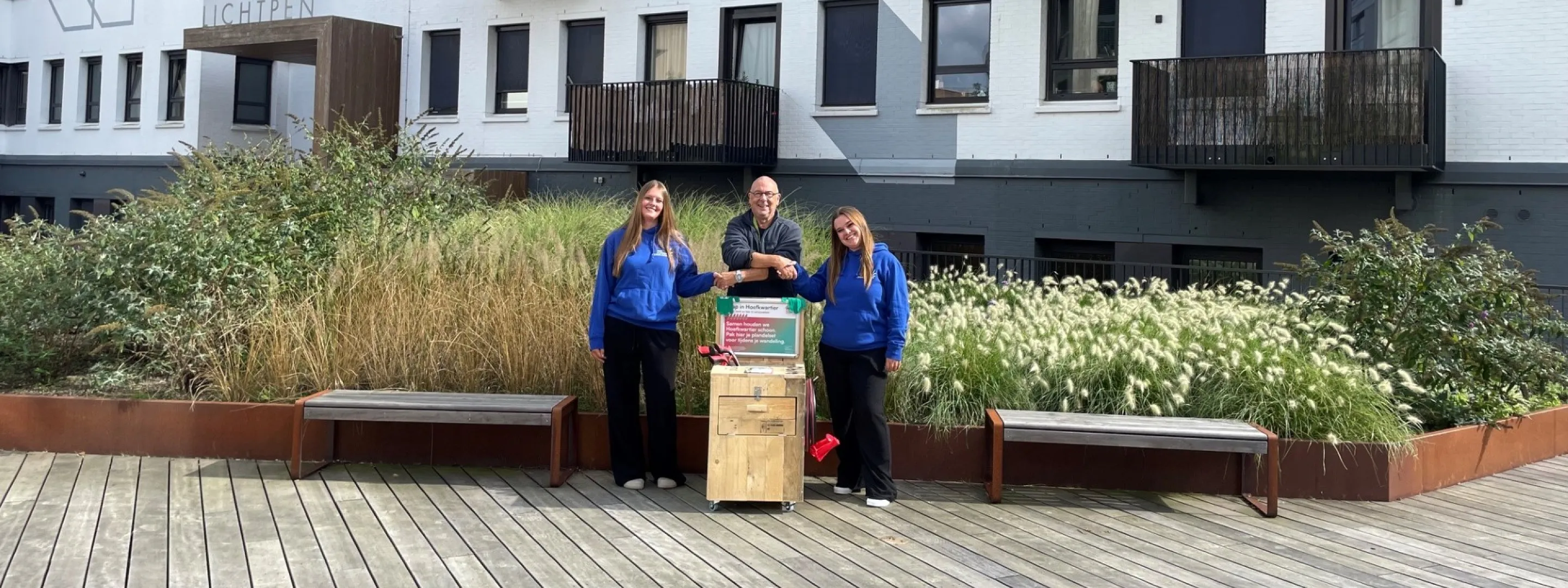 Studenten van het Bouw & Interieur College overhandigen een plandelbak aan een buurtbewoner in het Hoefkwartier in Amersfoort.