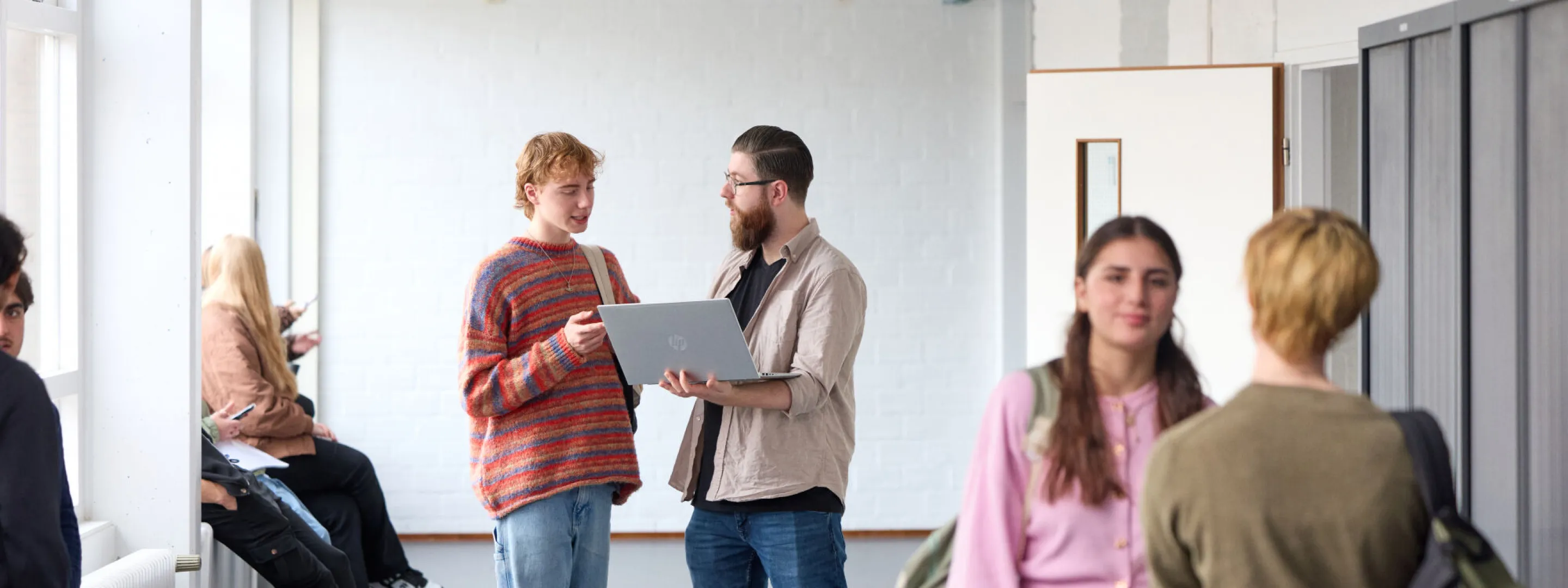 Docent VAVO Lyceum praat in gang met student