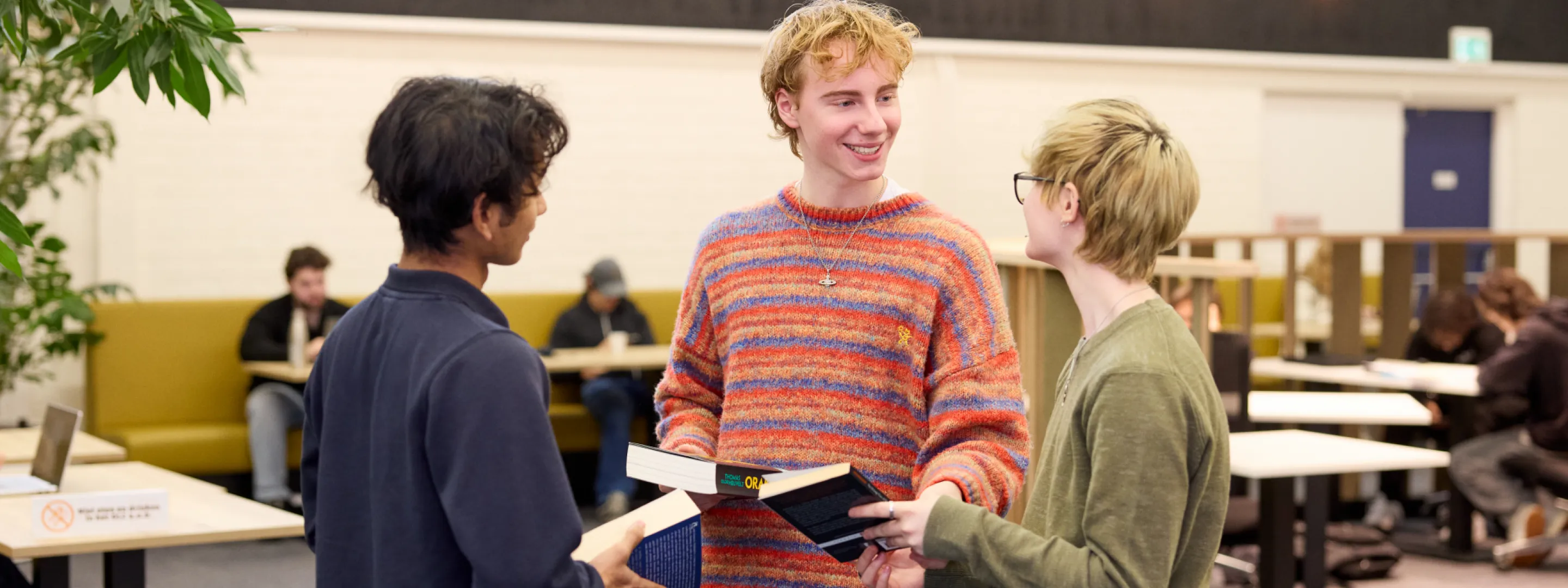 Studenten VAVO Lyceum praten met elkaar in de bibliotheek op school