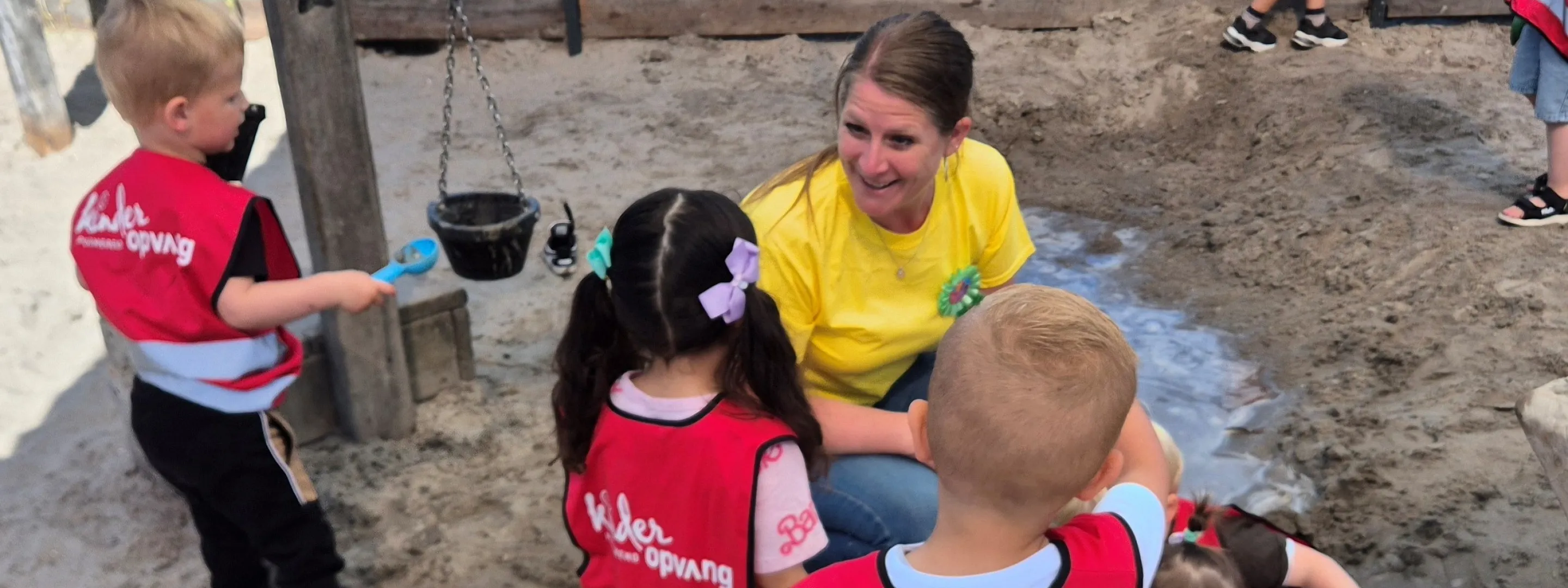 Wendy Jong, oud-student certificaten pedagogisch medewerker, met kinderen in zandbak